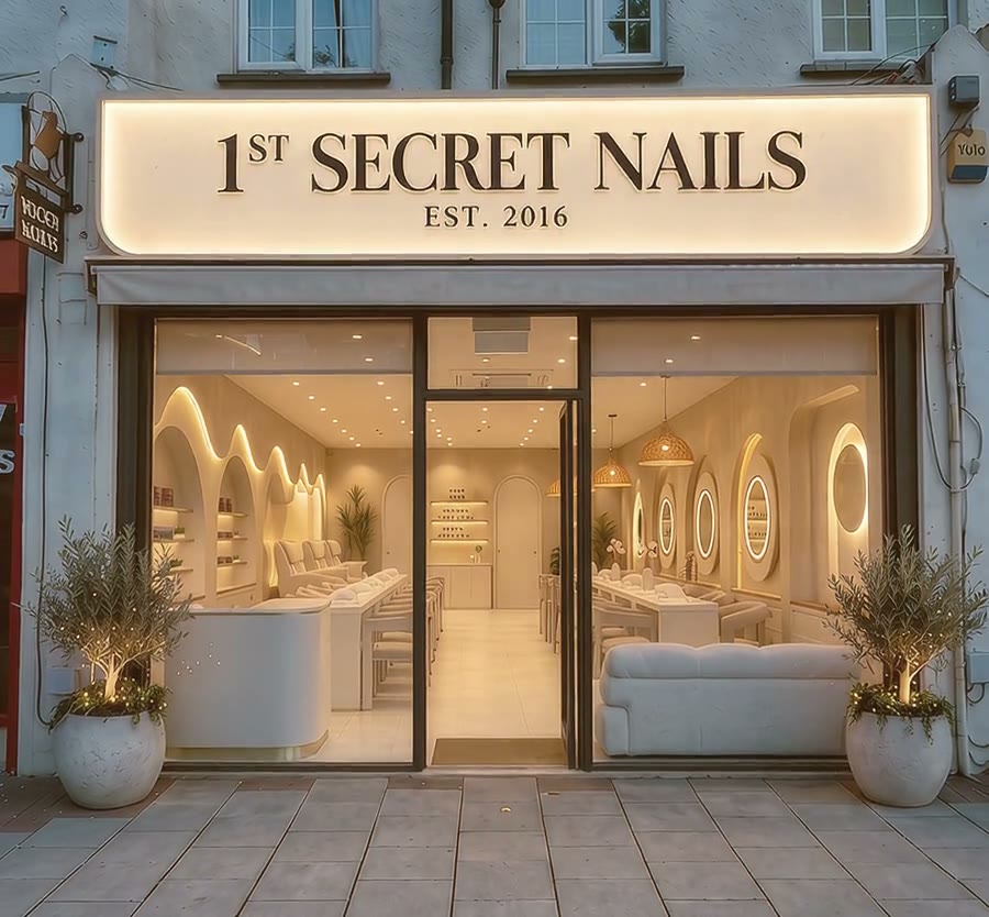 The 1st Secret Nails shopfront on Well Hall Road, lit at dusk